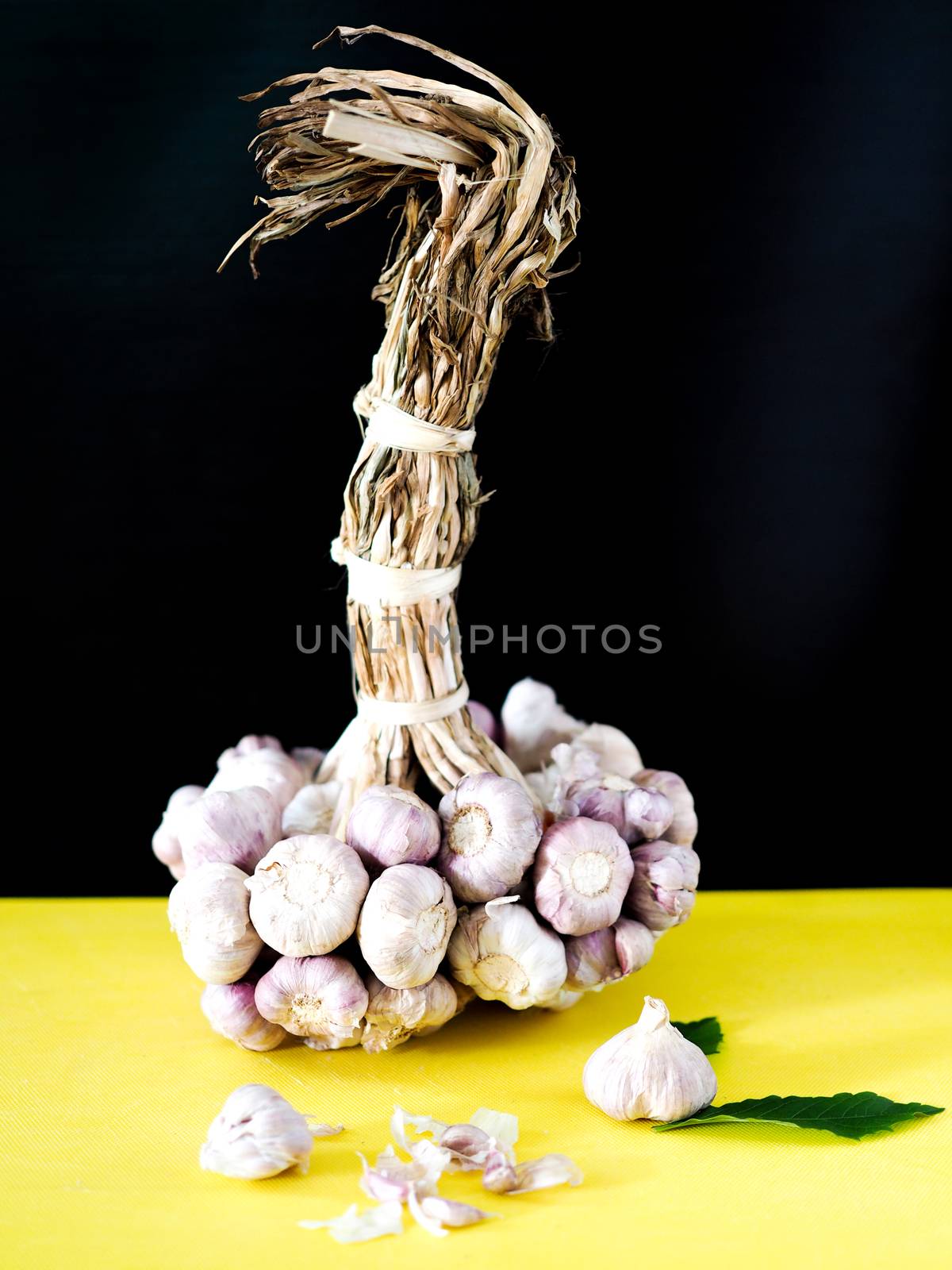 Garlic herbs and spices for cooking on yellow plastic cutting board