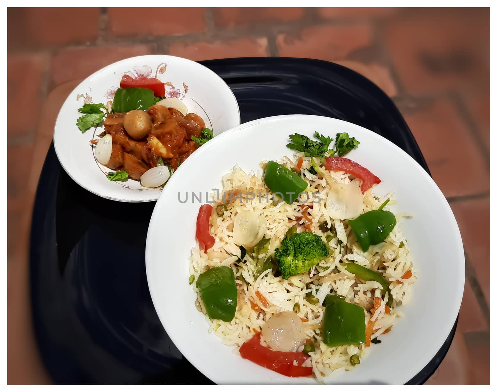 Colorful Delicious Veg fried rice with spicy indian mushroom gravy in white bowl and it's one of favorite restaurant cuisine food