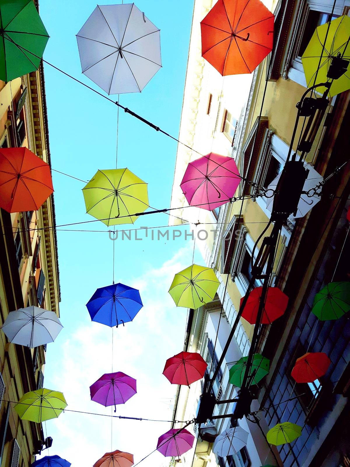 Genova, Italy - 06/01/2020: Bright abstract background of jumble of rainbow colored umbrellas over the city celebrating gay pride