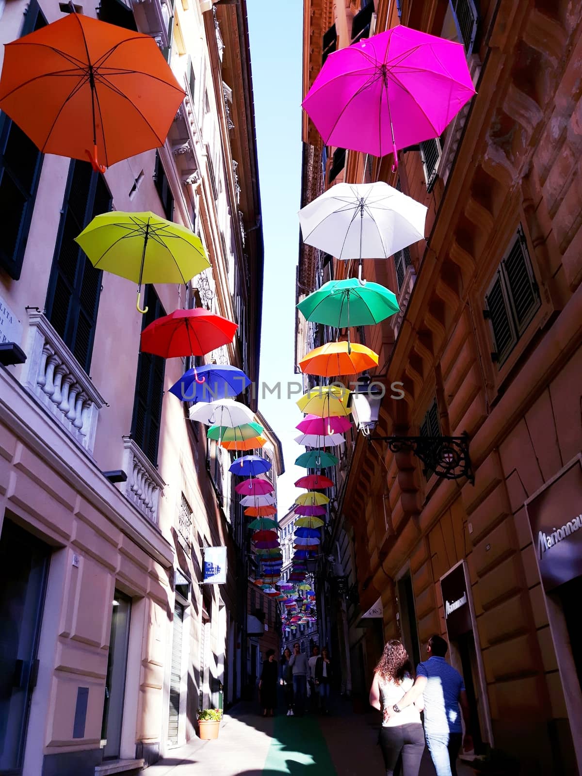 Genova, Italy - 06/01/2020: Bright abstract background of jumble of rainbow colored umbrellas over the city celebrating gay pride