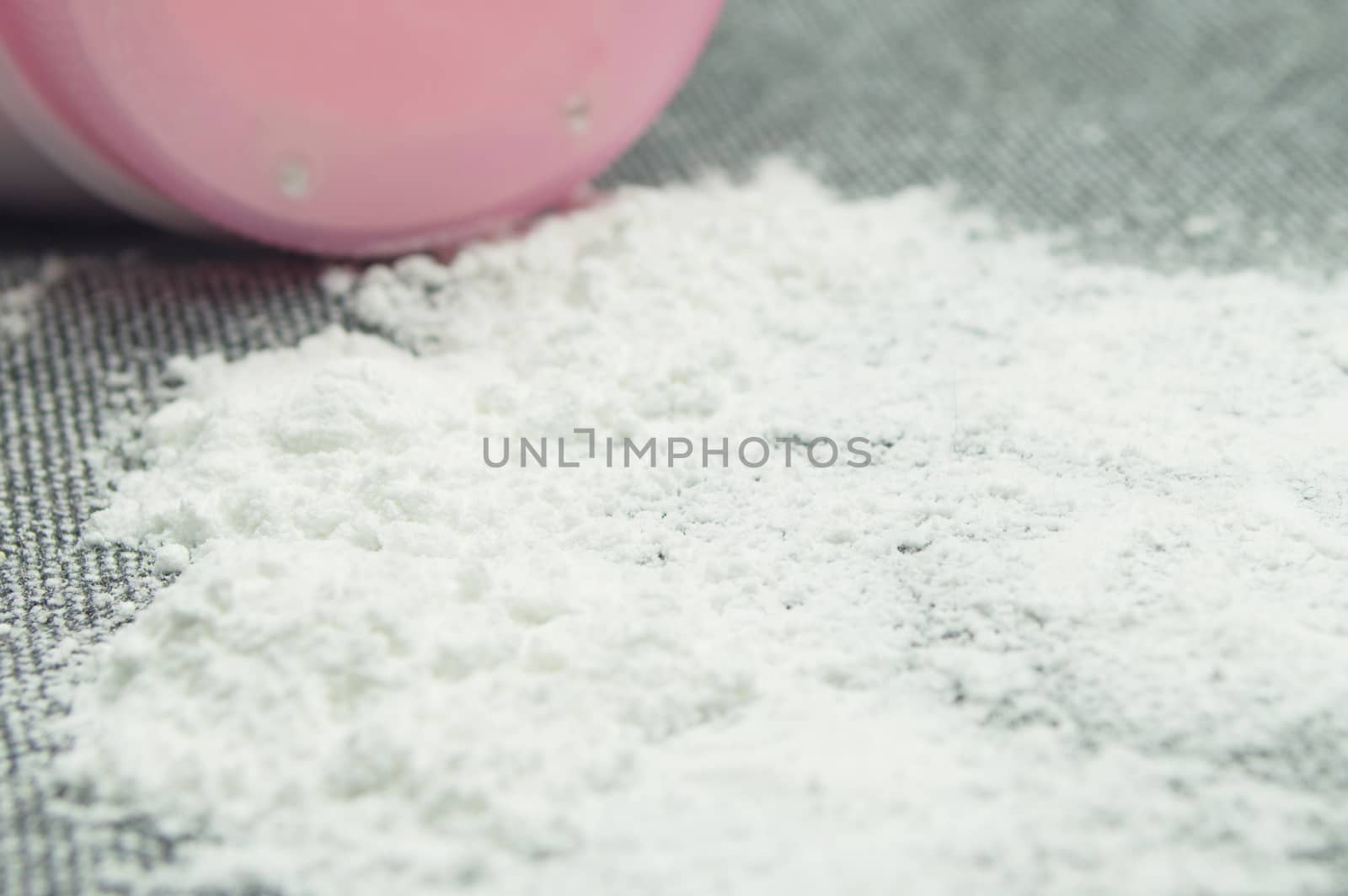 Baby talcum powder container on gray fabric background