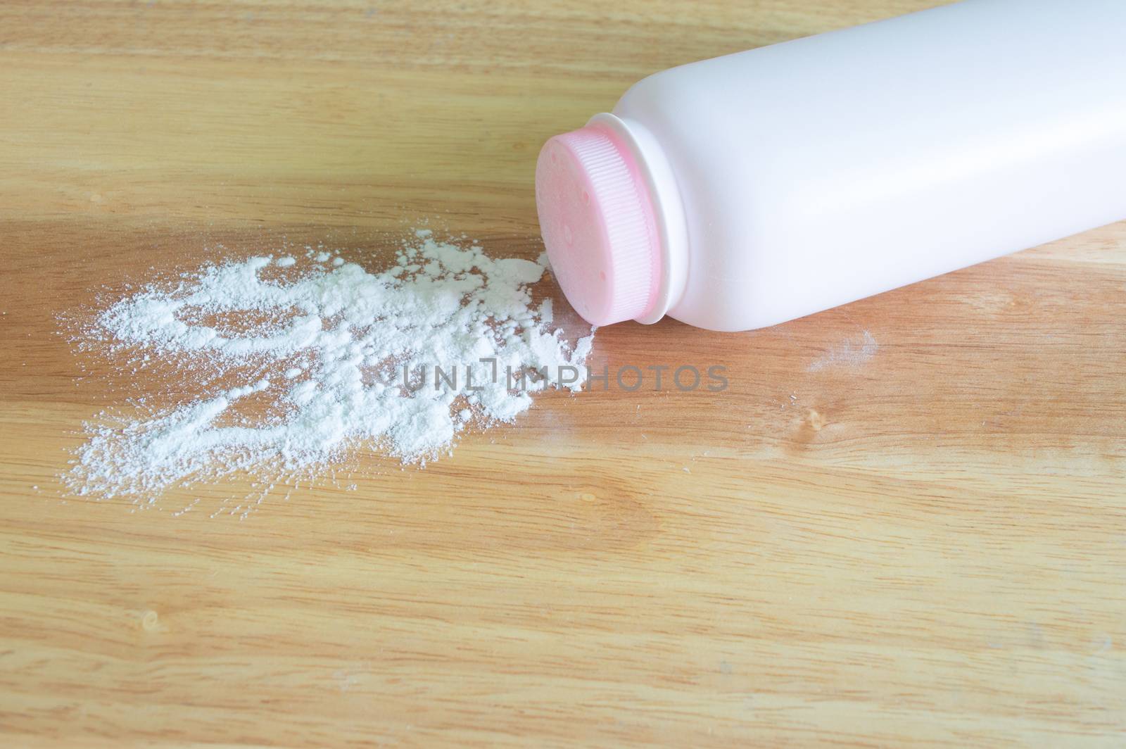 pink talcum baby powder container on wooden background