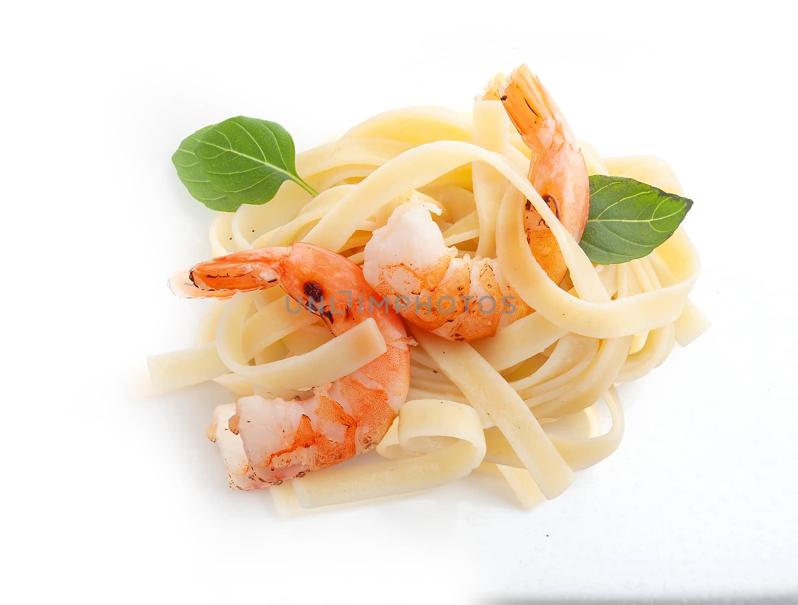 Roasted shrimps with pasta and fresh basil on the white background