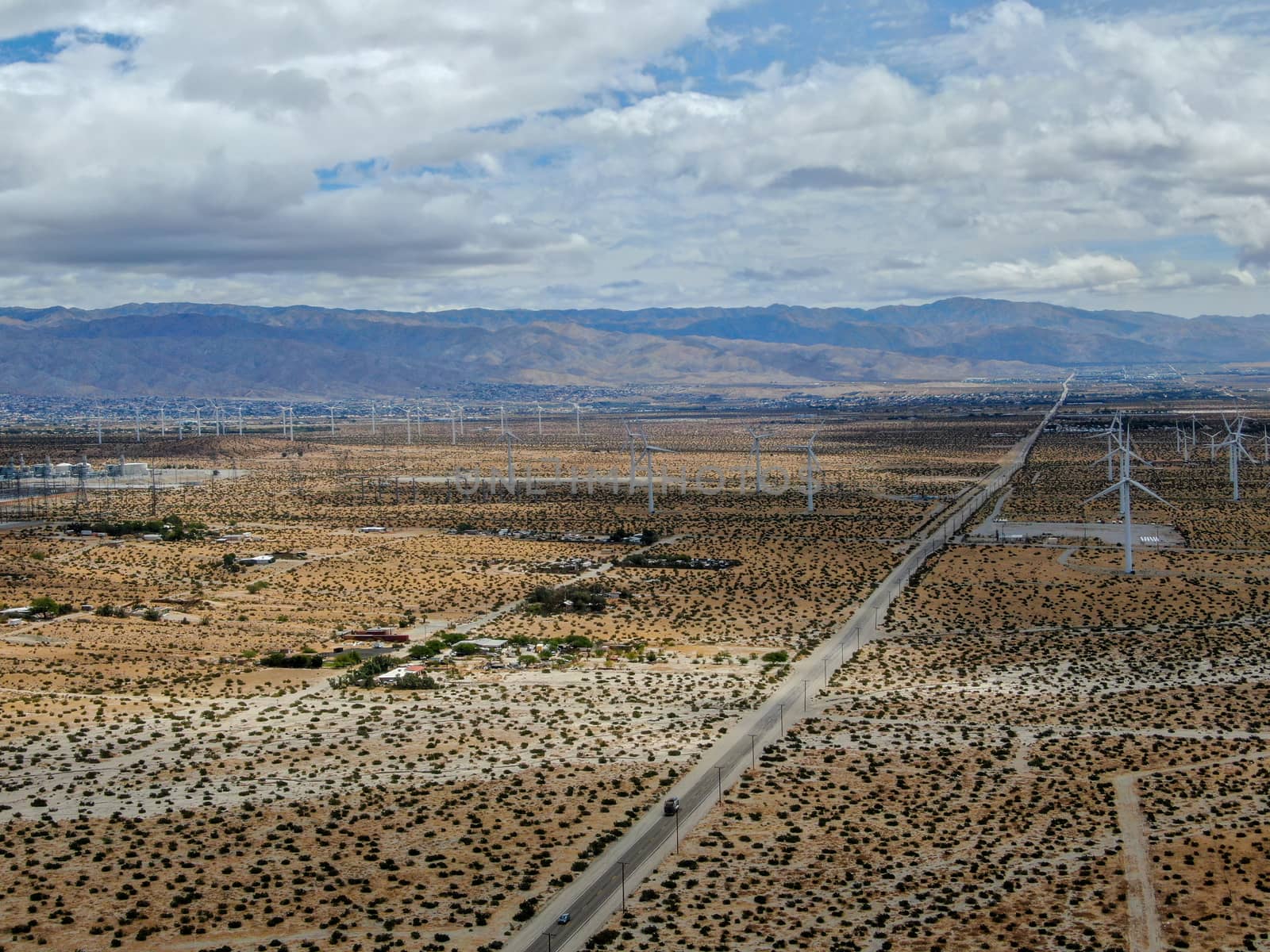 Aerial view of huge array of gigantic wind turbines spreading over the desert in Palm Springs wind farm. California. USA. Aerial view of wind turbines generating electricity. 