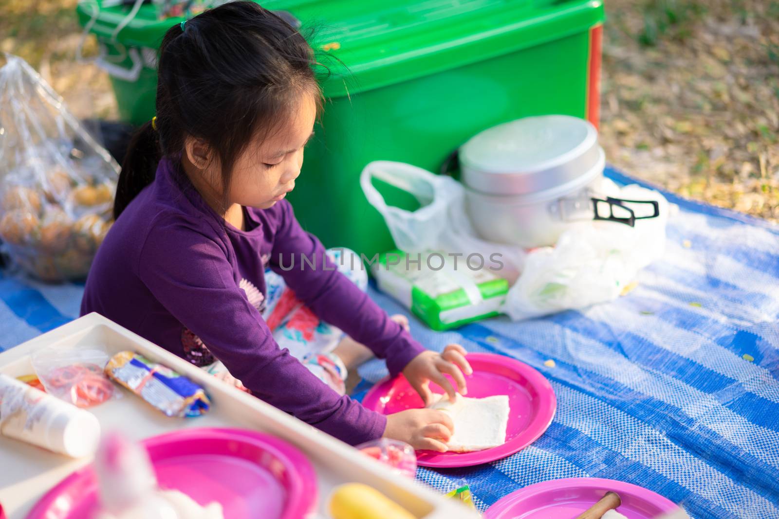 little girl making breakfast between camping