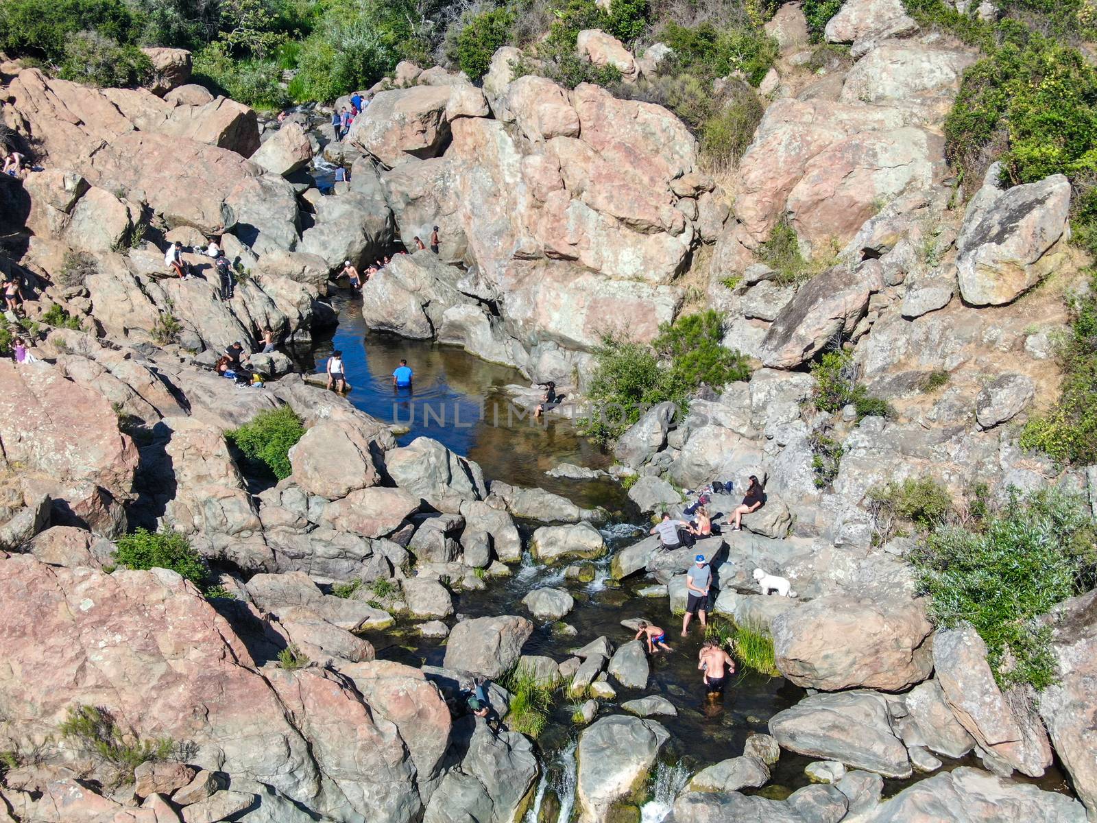 Aerial view of Los Penasquitos Canyon Preserve with the creek waterfall and people enjoying the water. Urban park with trails and river in San Diego, California. USA