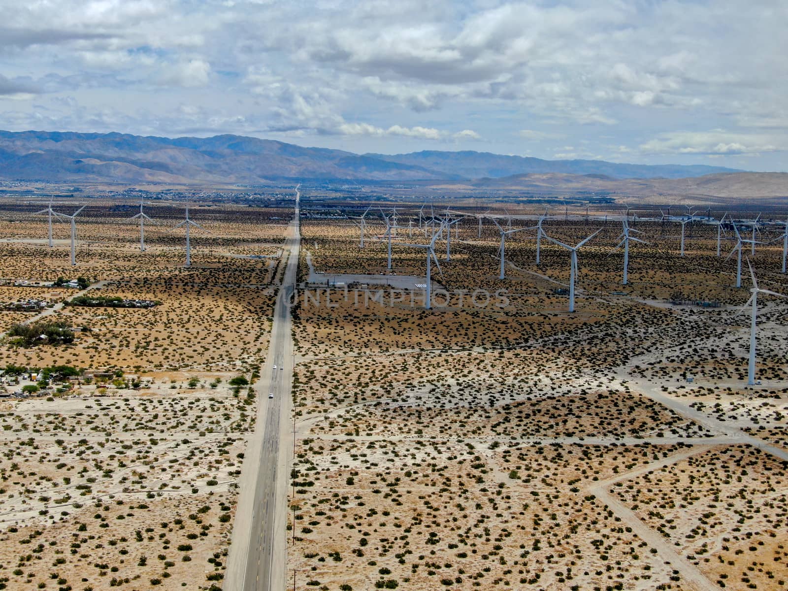 Aerial view of huge array of gigantic wind turbines spreading over the desert in Palm Springs wind farm. California. USA. Aerial view of wind turbines generating electricity. 