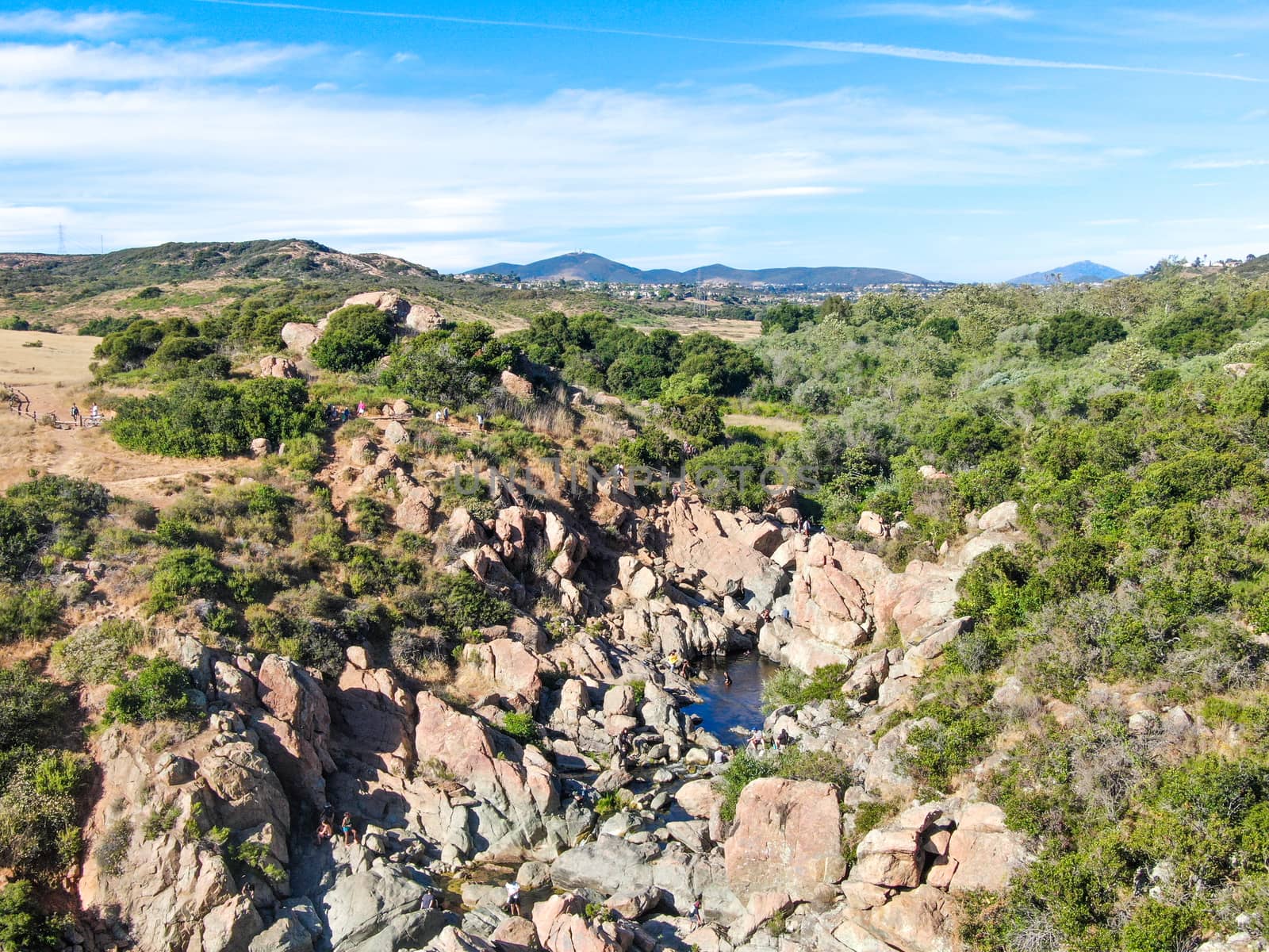 Aerial view of Los Penasquitos Canyon Preserve with the creek waterfall and people enjoying the water. Urban park with trails and river in San Diego, California. USA