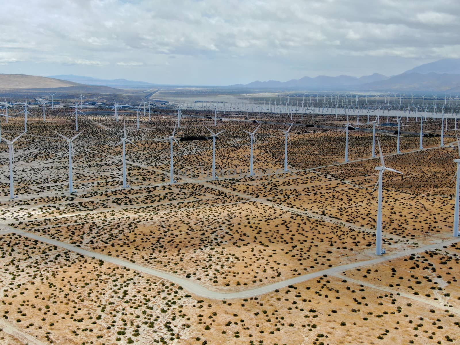 Aerial view of huge array of gigantic wind turbines spreading over the desert in Palm Springs wind farm. California. USA. Aerial view of wind turbines generating electricity. 