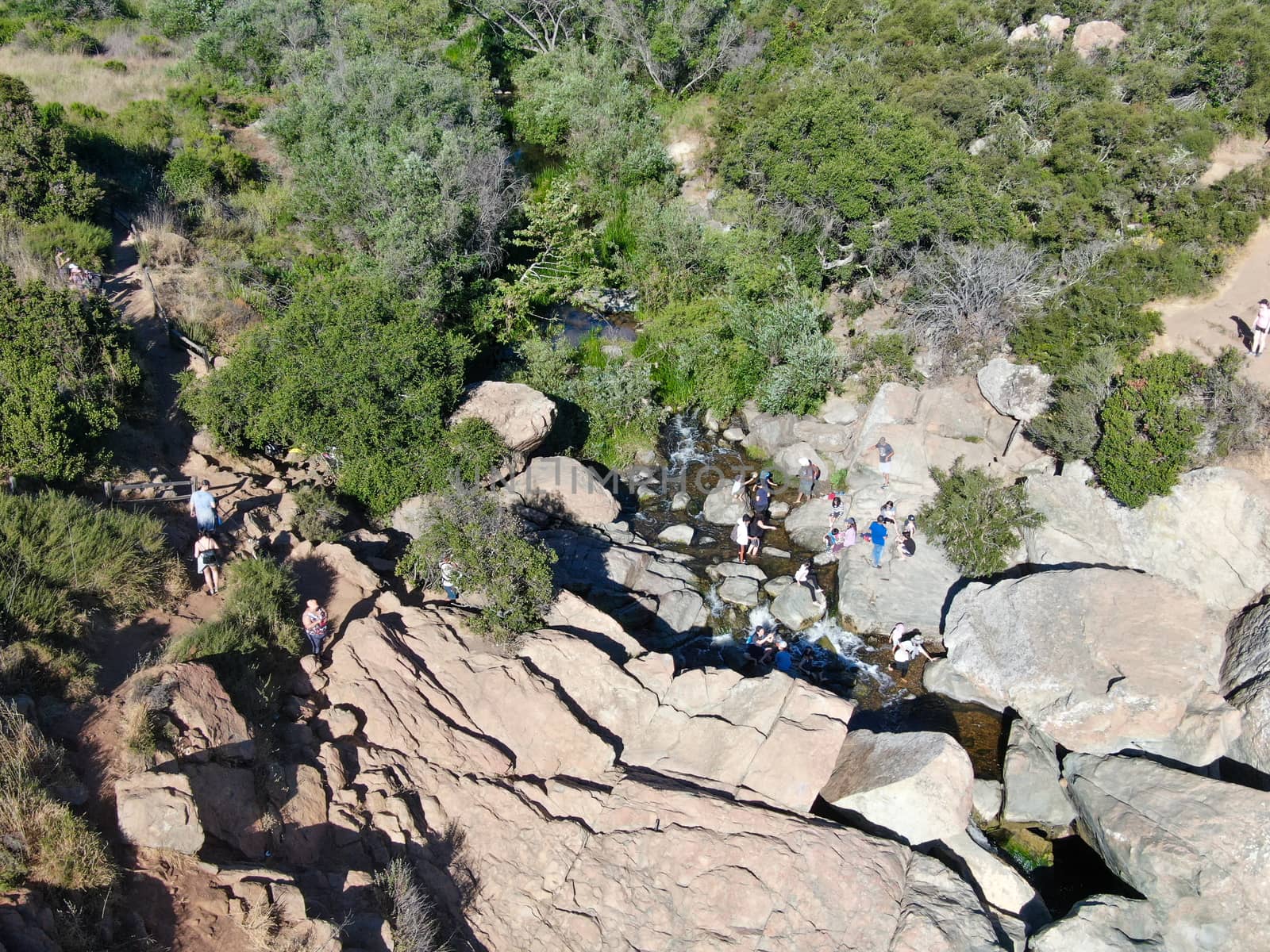 Aerial view of Los Penasquitos Canyon Preserve with the creek waterfall and people enjoying the water. Urban park with trails and river in San Diego, California. USA