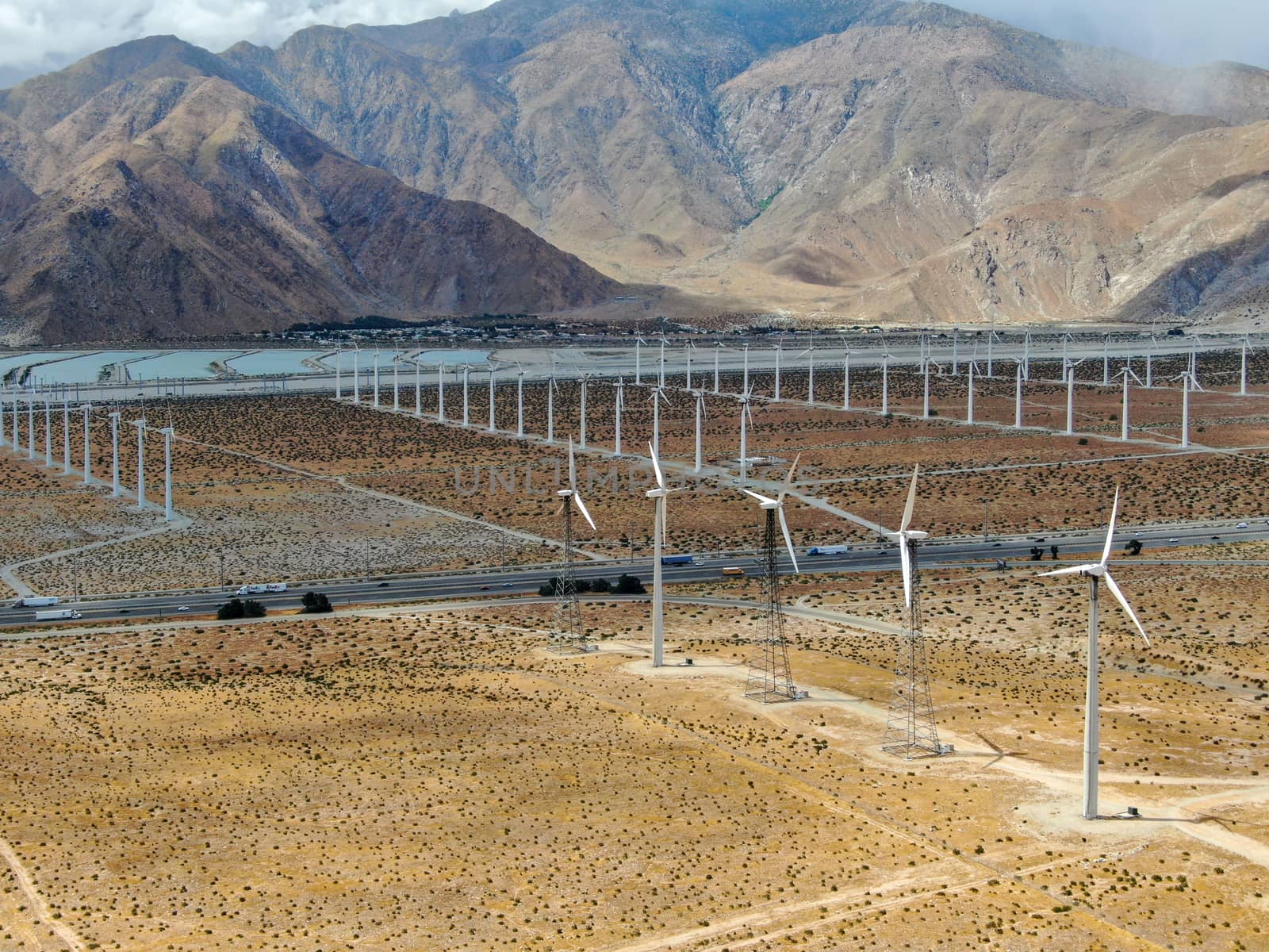 Aerial view of huge array of gigantic wind turbines spreading over the desert in Palm Springs wind farm. California. USA. Aerial view of wind turbines generating electricity. 