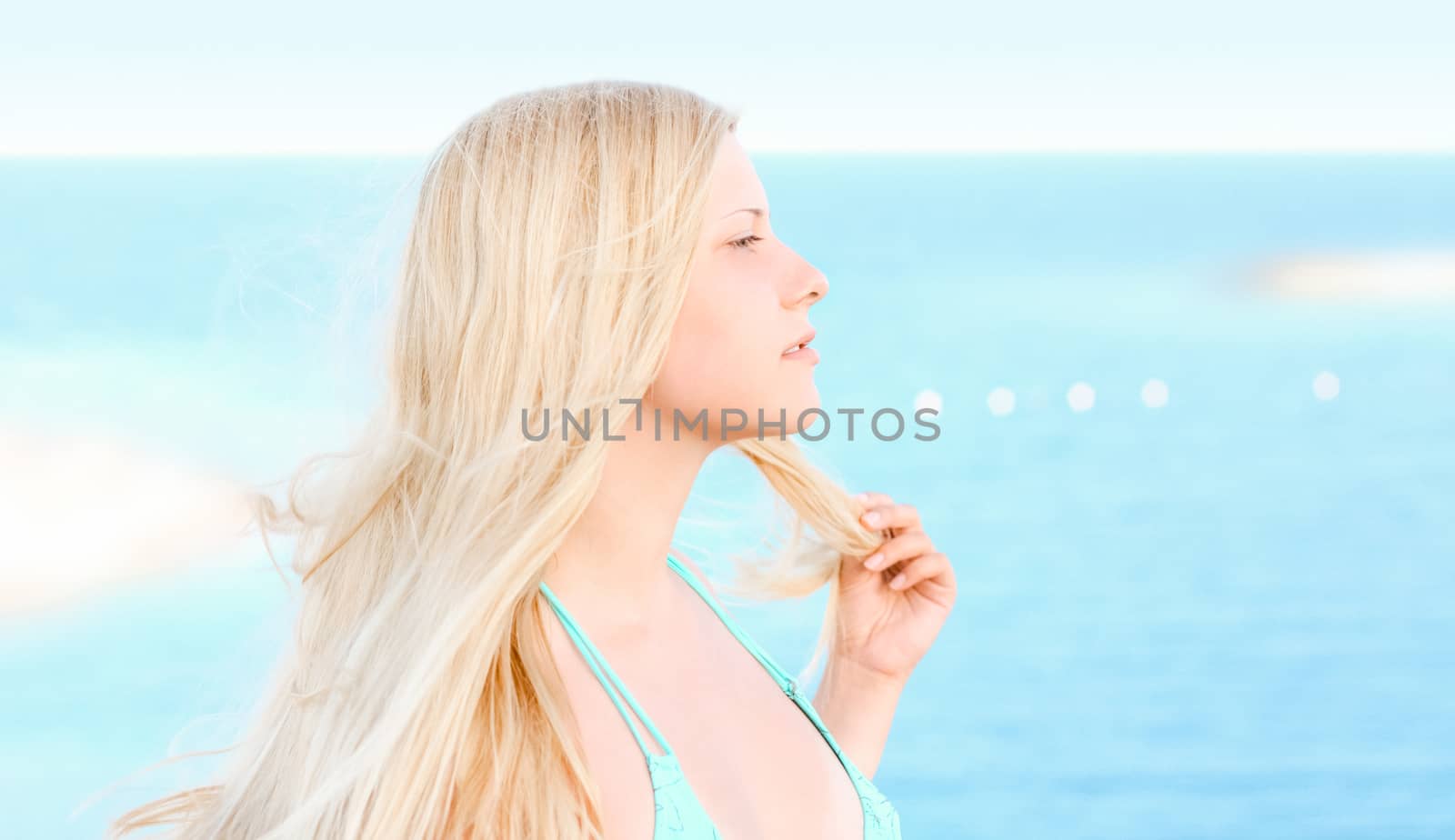 Woman with blond hair enjoying seaside and beach lifestyle in summertime, holiday travel and leisure concept