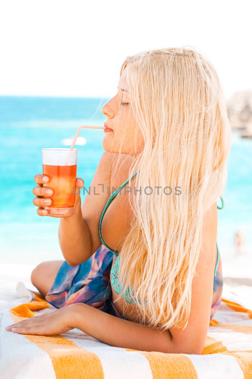 Woman with blond hair enjoying cocktail drink and beach lifestyle in summertime, holiday travel and leisure concept