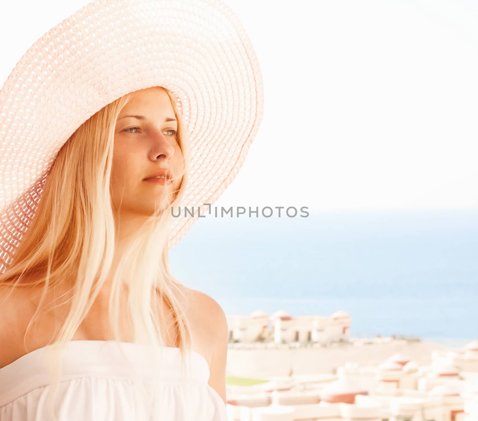 Woman with blond hair wearing hat, enjoying seaside and beach lifestyle in summertime, holiday travel and leisure concept