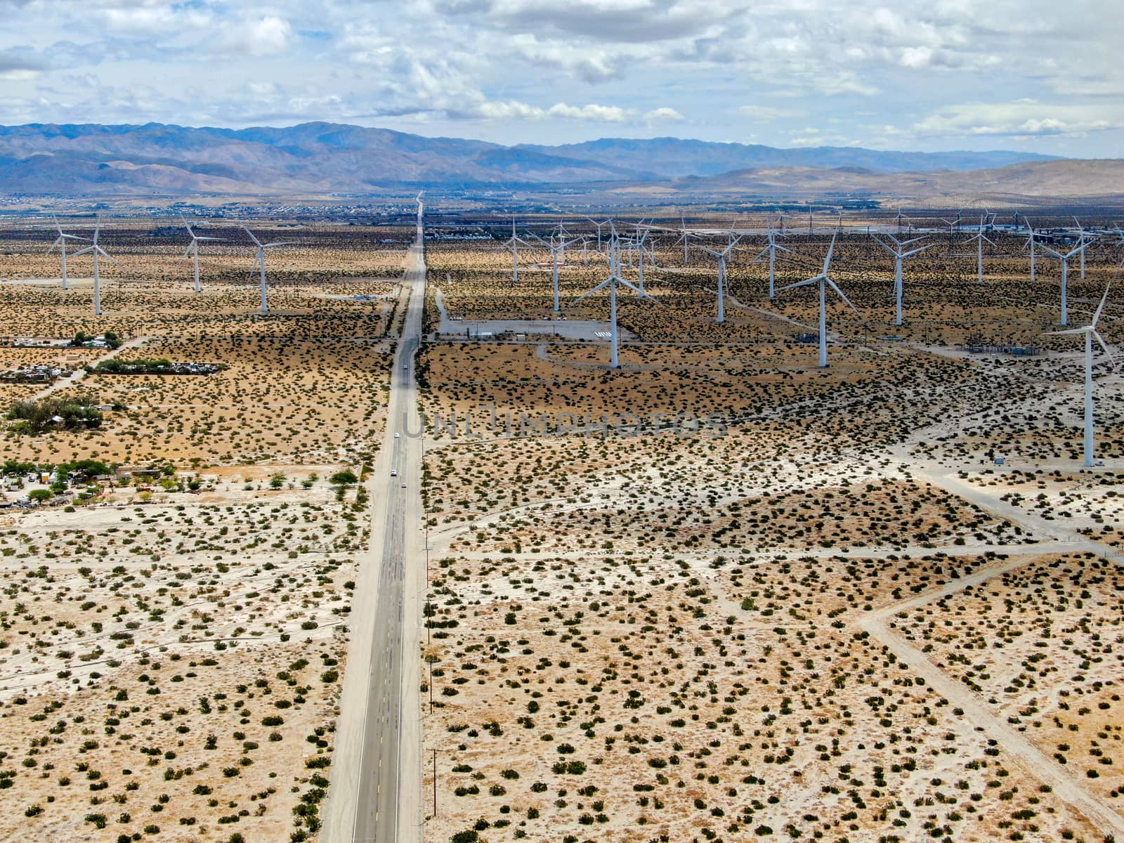 Aerial view of huge array of gigantic wind turbines spreading over the desert in Palm Springs wind farm. California. USA. Aerial view of wind turbines generating electricity. 