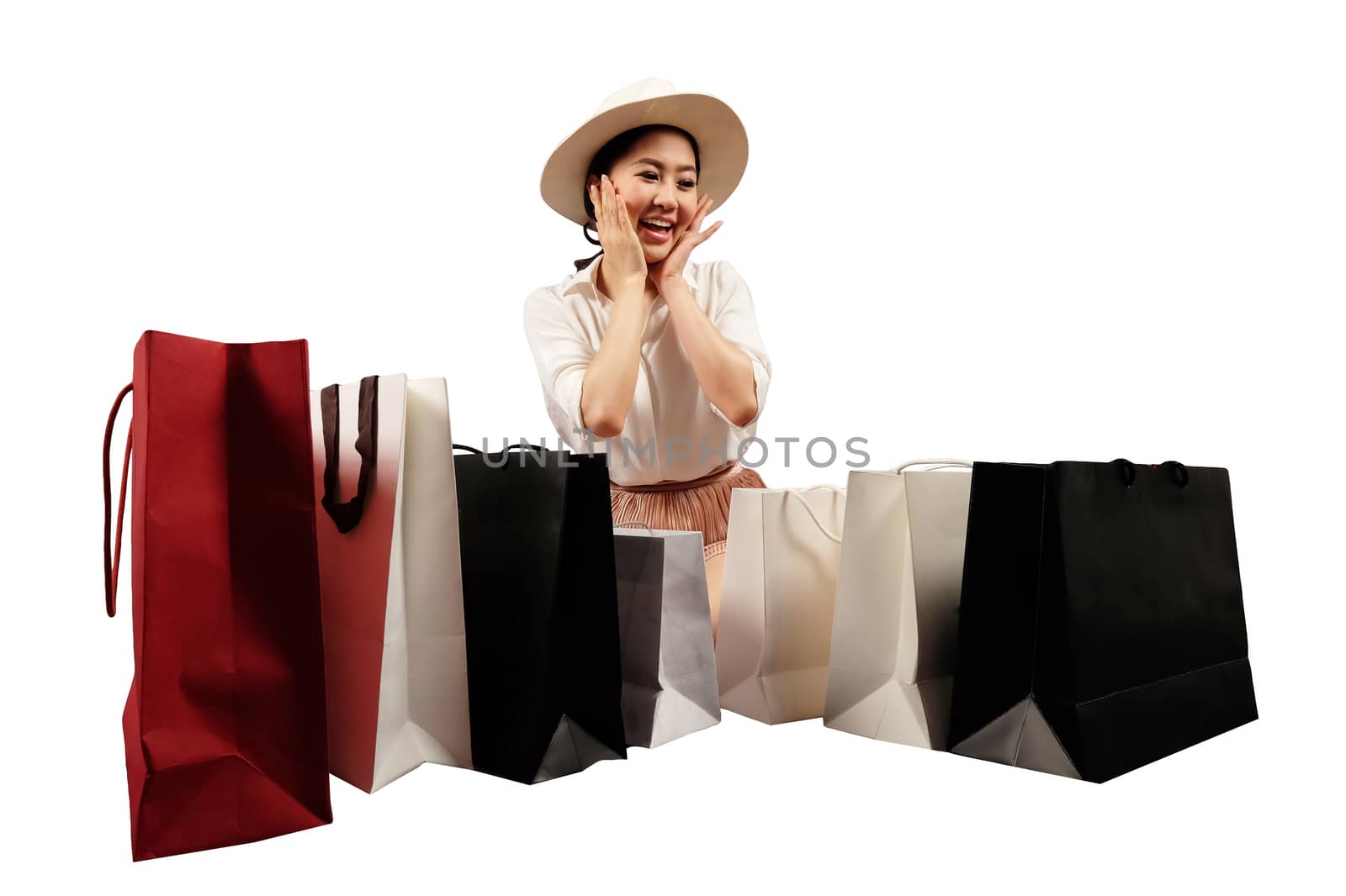 a happy shopaholic women opening a shopping bag on white backgro by Surasak