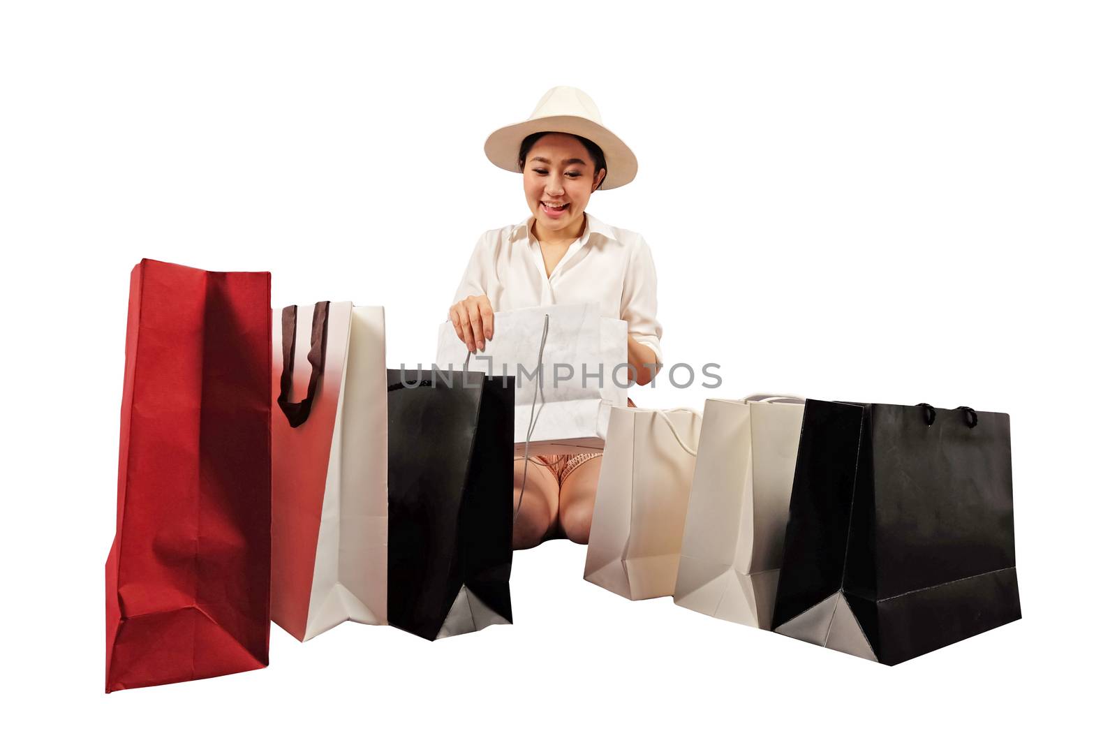 a happy shopaholic women opening a shopping bag by Surasak