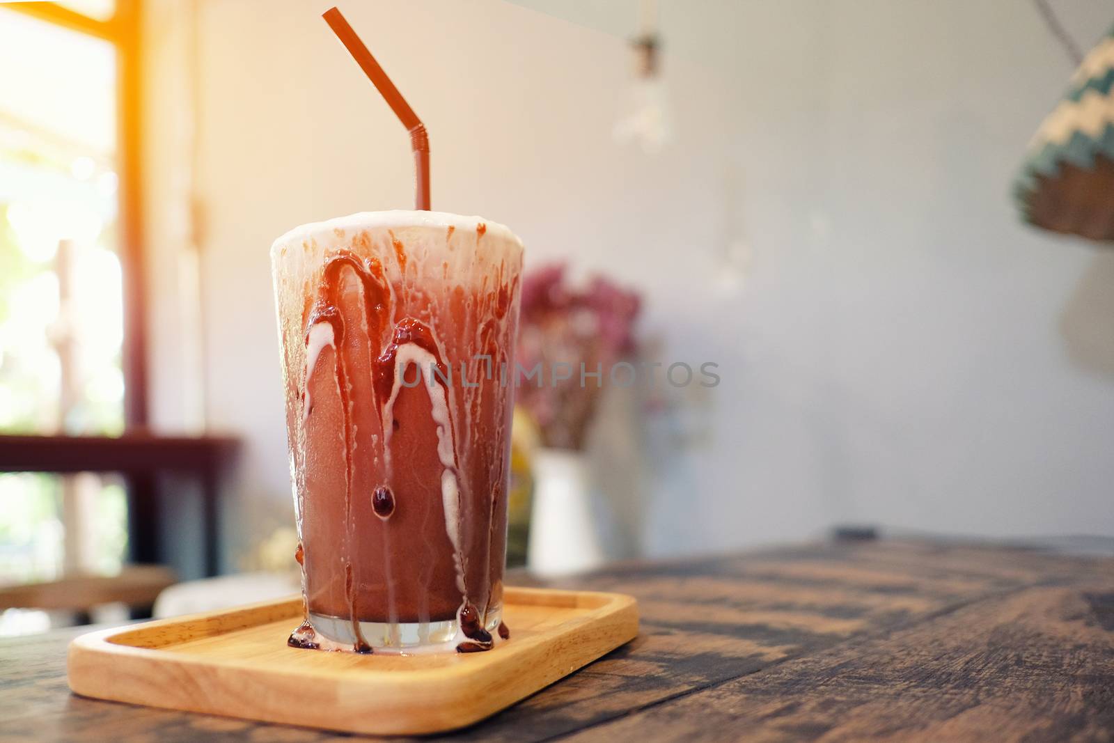 Iced chocolate shake on wood and sunlight background