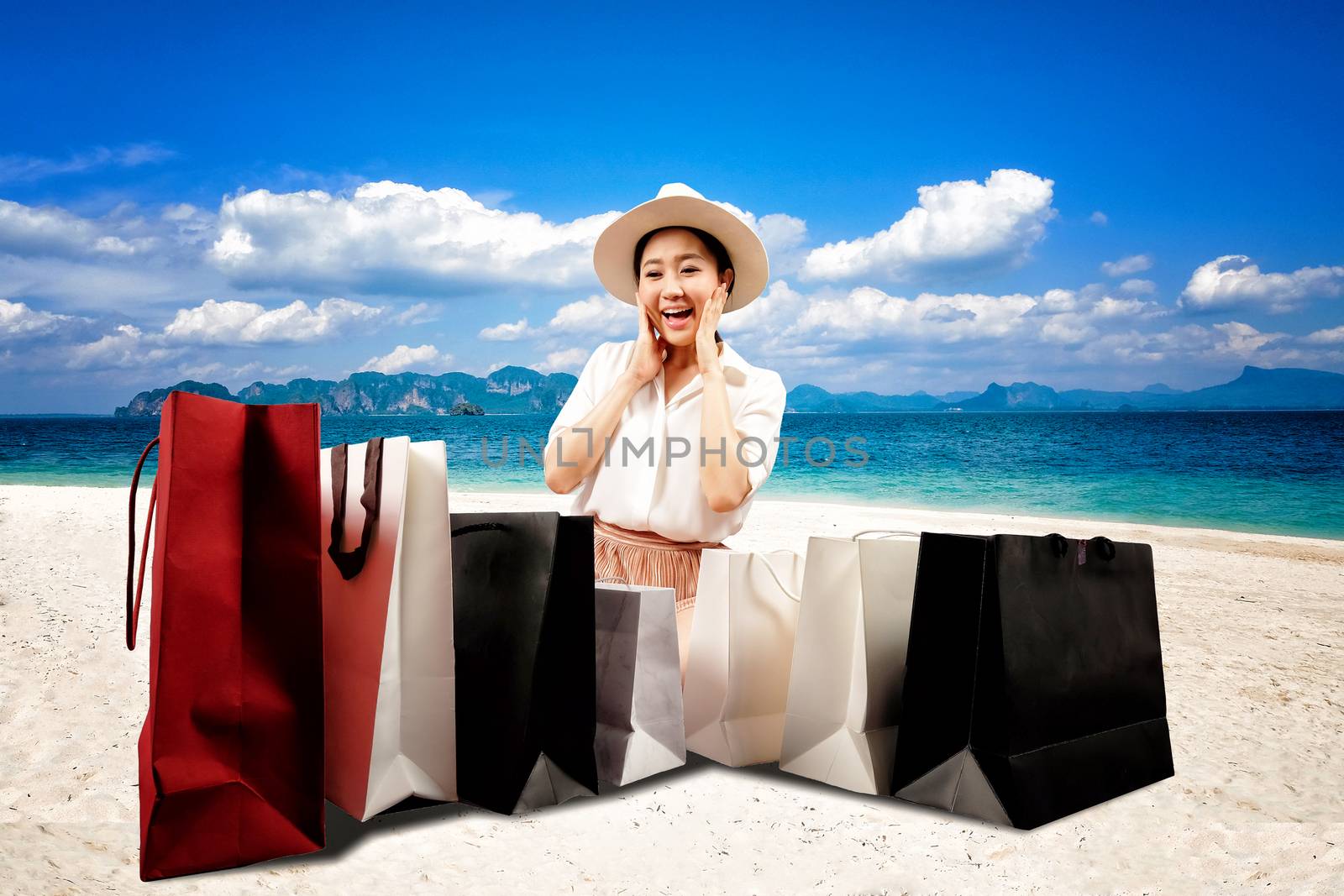 Summer sale a happy shopaholic women opening a shopping bag on the beach