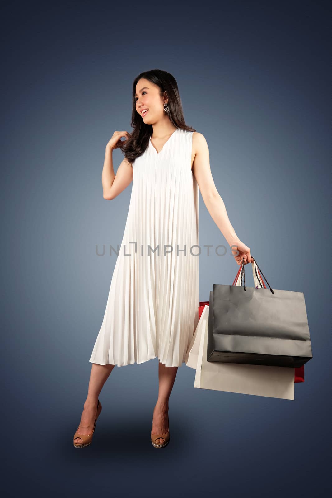 a happy women with shopping bag on dark blue background with cli by Surasak
