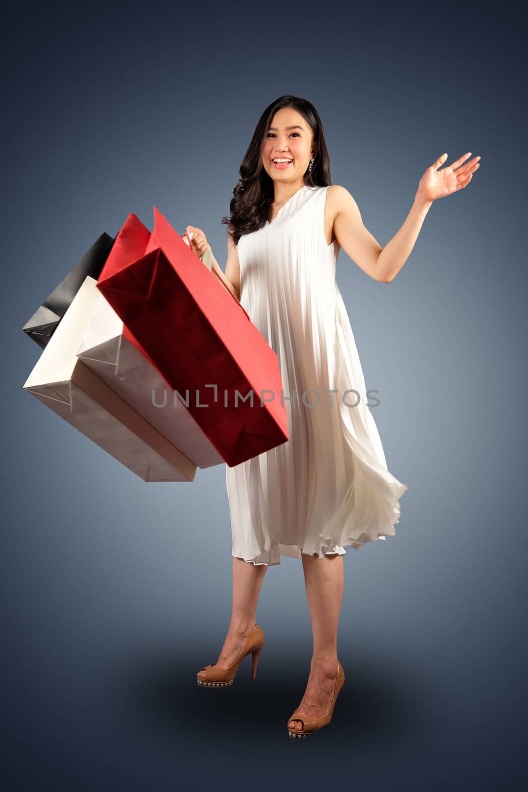 a happy women in white dress with a shopping bag on white background and clipping path