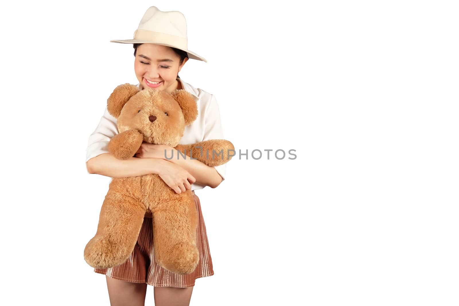 Lovely smiling young woman with hat holding big soft teddy bear  by Surasak