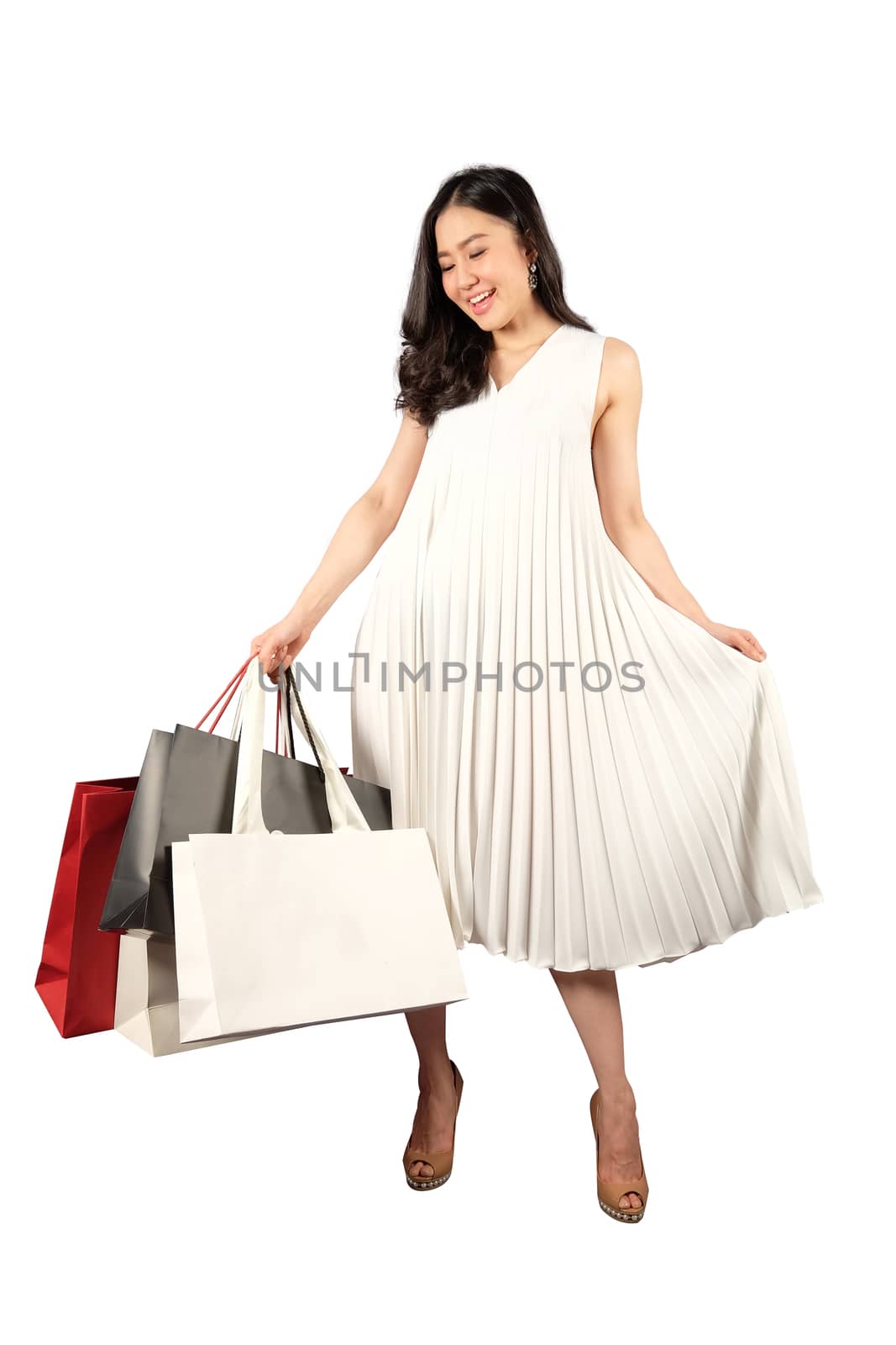 a happy women in white dress with a shopping bag on white backgr by Surasak