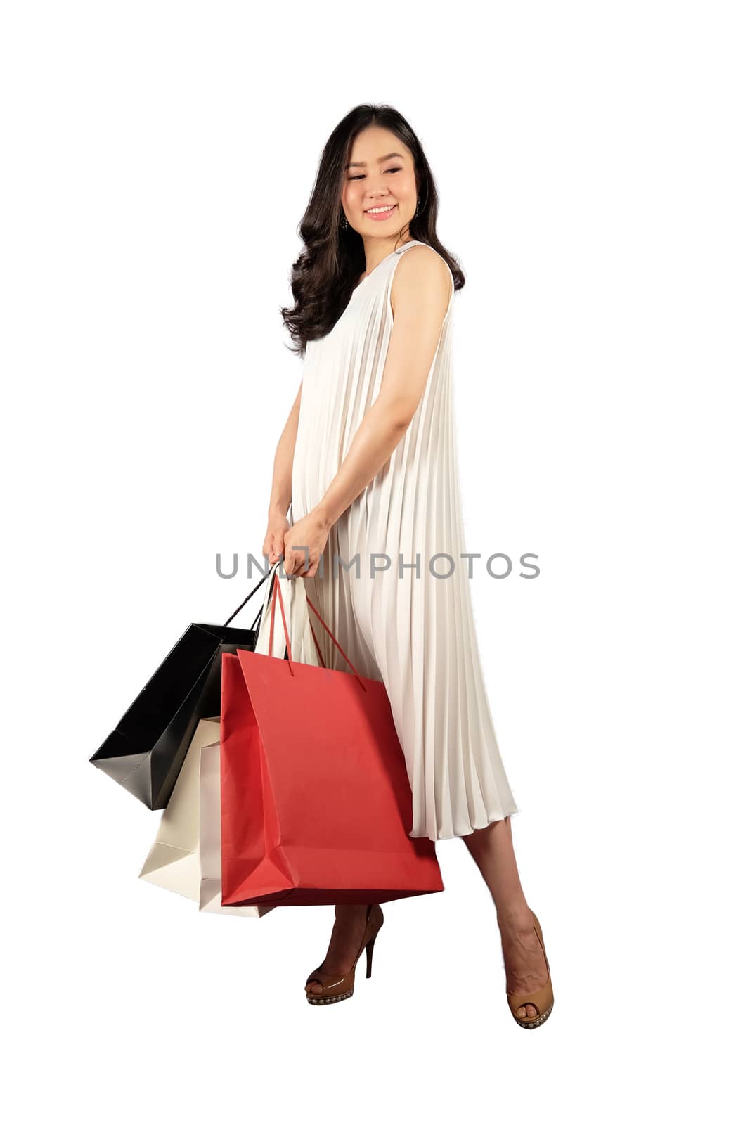 a happy women in white dress with a shopping bag on white background and clipping path 