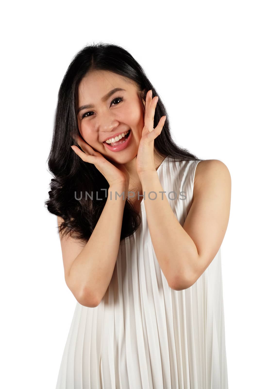 Happy woman wearing white dress looking at camera and white back by Surasak