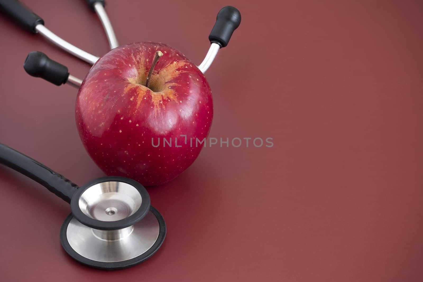 A red apple on dark brown background by Nawoot