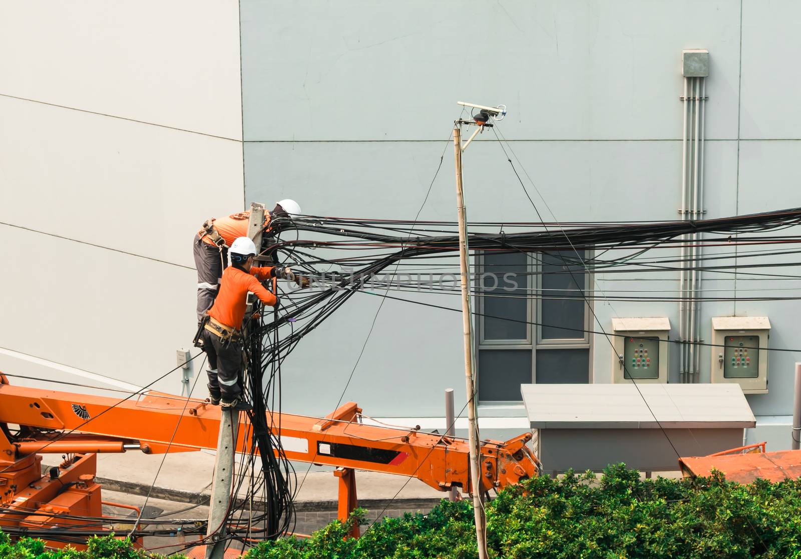 Electricians Engineer are climbing on electric poles to install and repair power lines.
