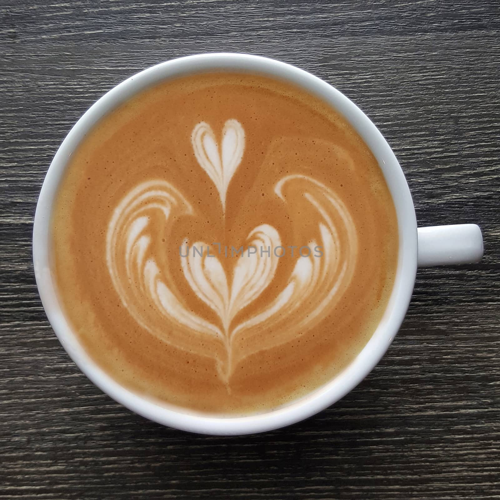 Top view of a mug of latte art coffee. by Tanarch