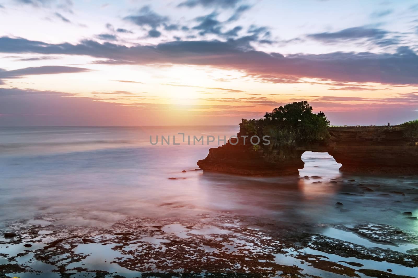 Sunset near famous tourist landmark of Bali island - Tanah Lot & Batu Bolong temple. Long exposure effect, Bali Indonesia. Tropical nature landscape of Indonesia, Bali.