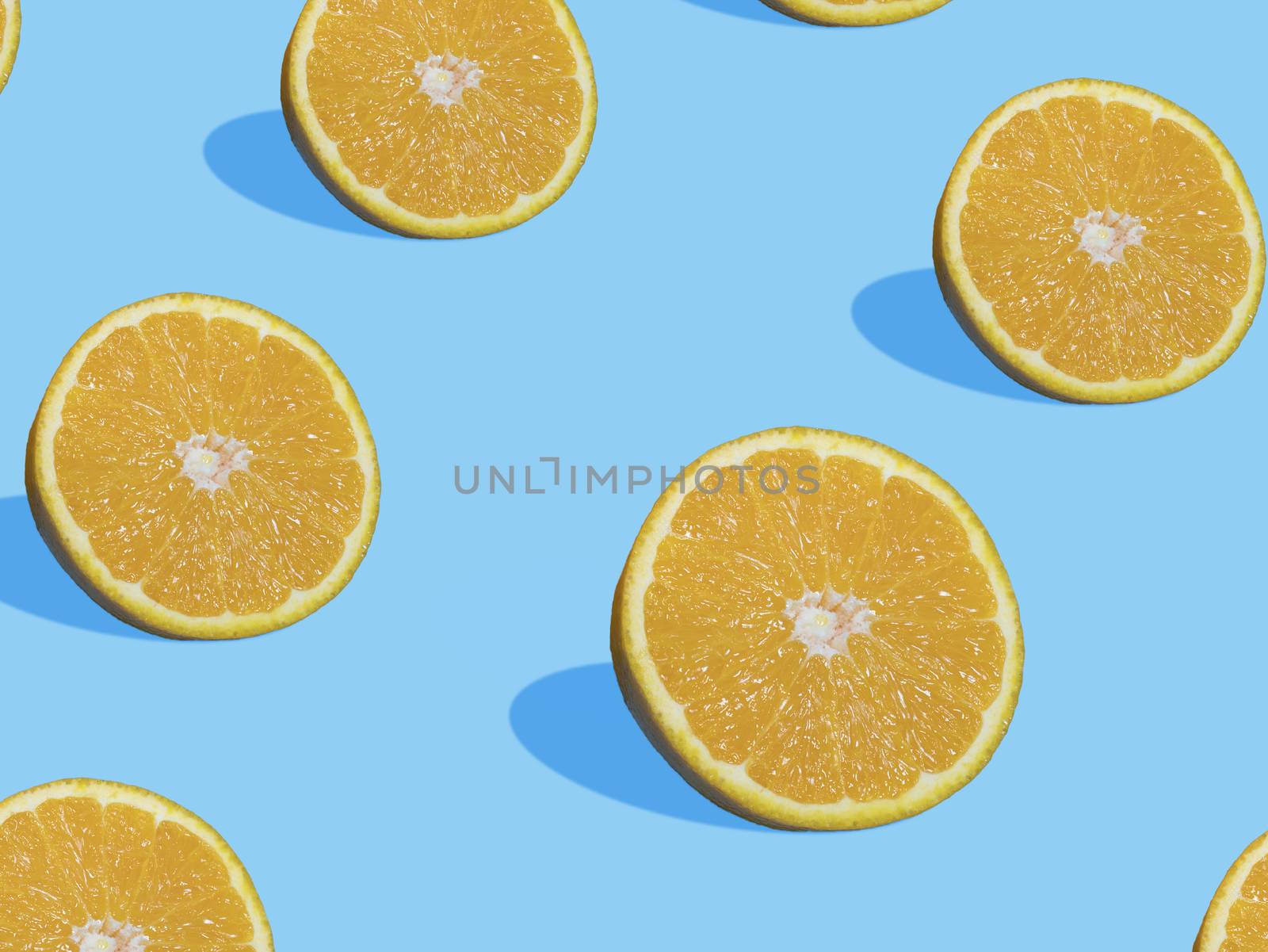 Fresh orange slices on blue background with shadow , top view, flat lay, close up , pattern. Summer and healthy citrus fruit concept by asiandelight