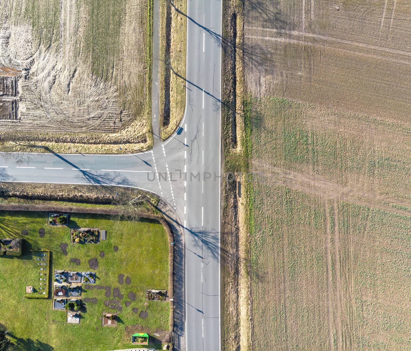 Aerial view of the turn off to the left of a country road in Germany. Abstract impression due to vertical angle of view. Made with drone