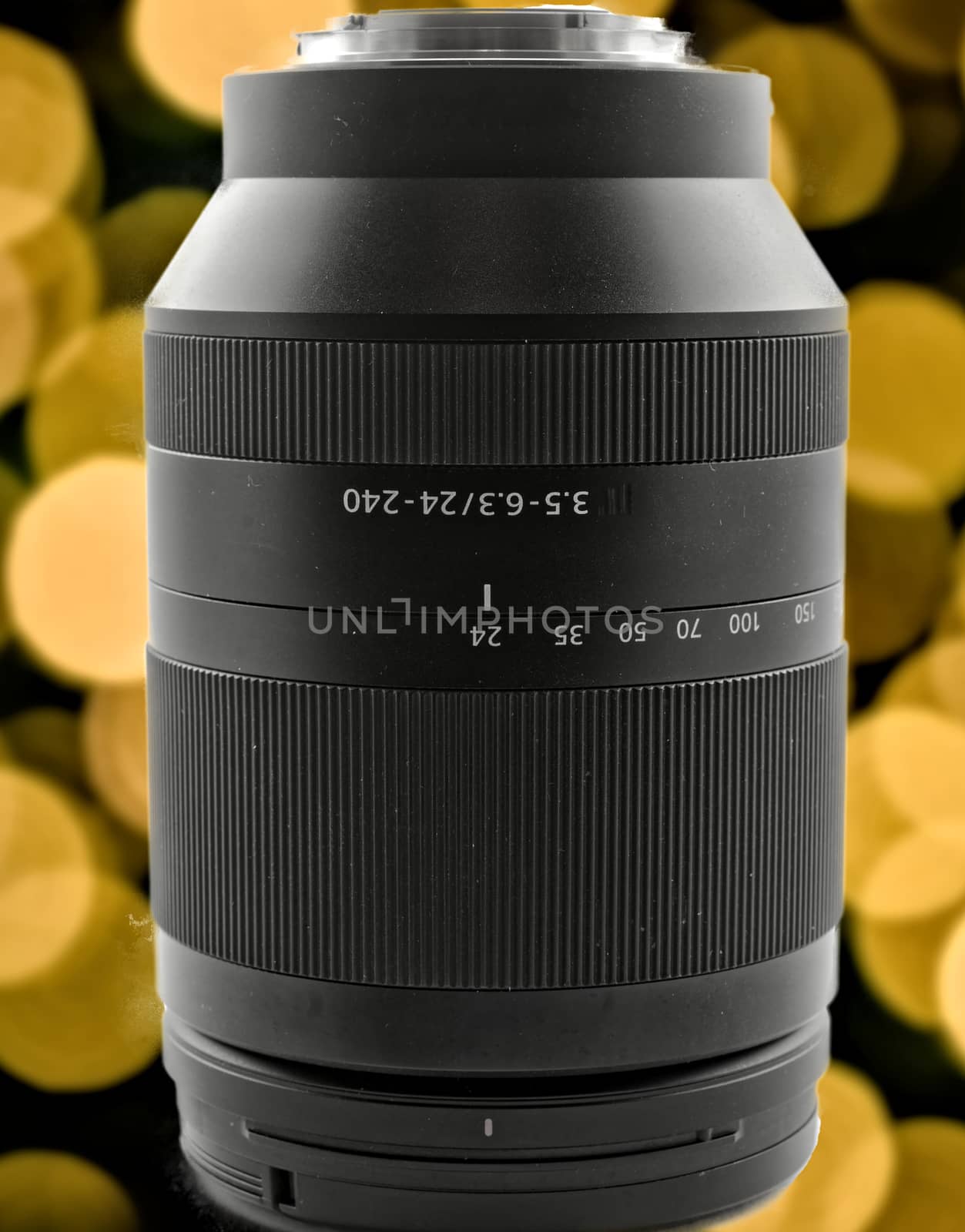Zoom lens with a focal length of 24 to 240 mm in front of a background with yellow and orange bokeh.