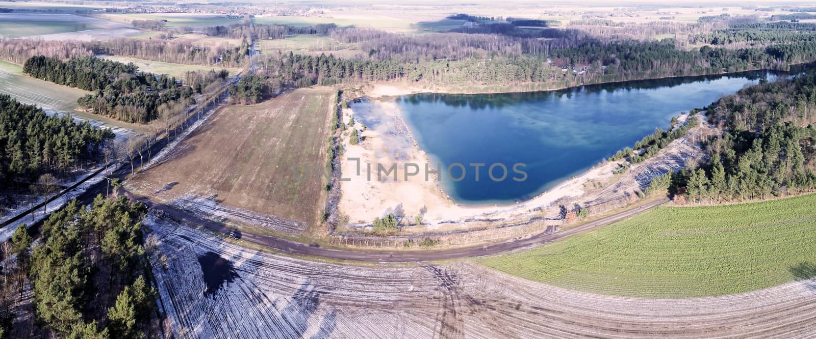 Aerial landscape photo, aerial photo with a lake, fields, meadows, forests and a road, panorama as a banner for a blog or a website, drone landscape photo.