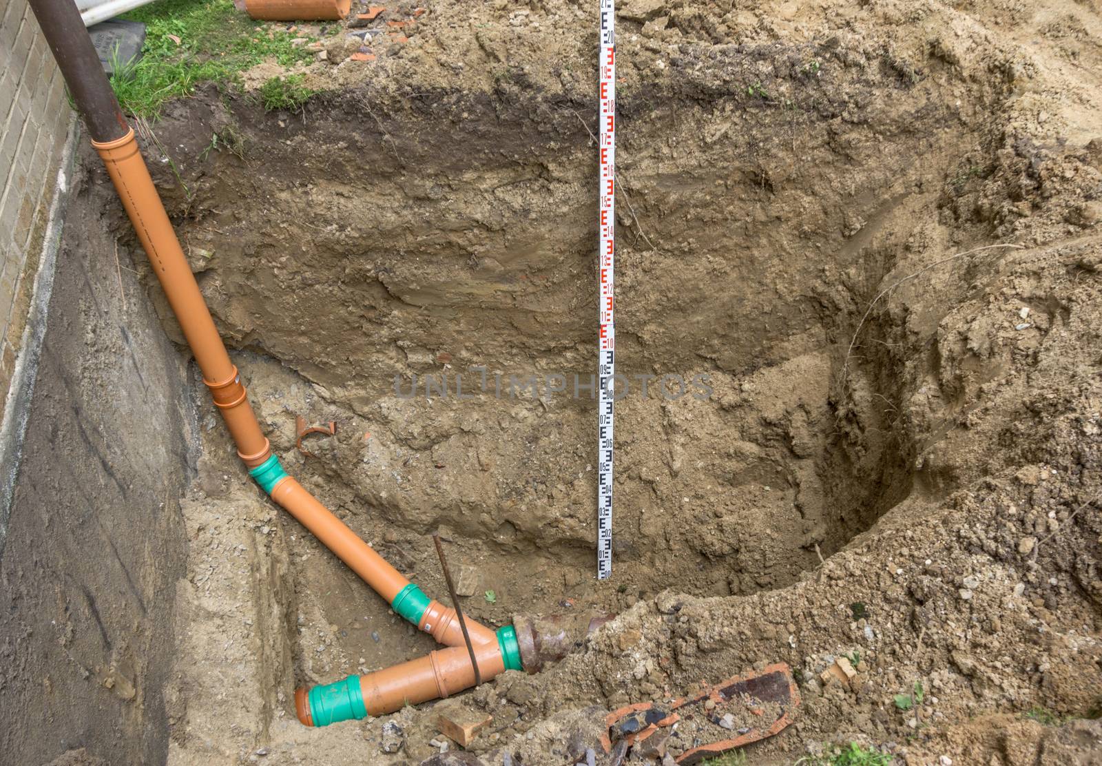 Laying a sewage pipe at the corner of a terraced house in Germany, construction site