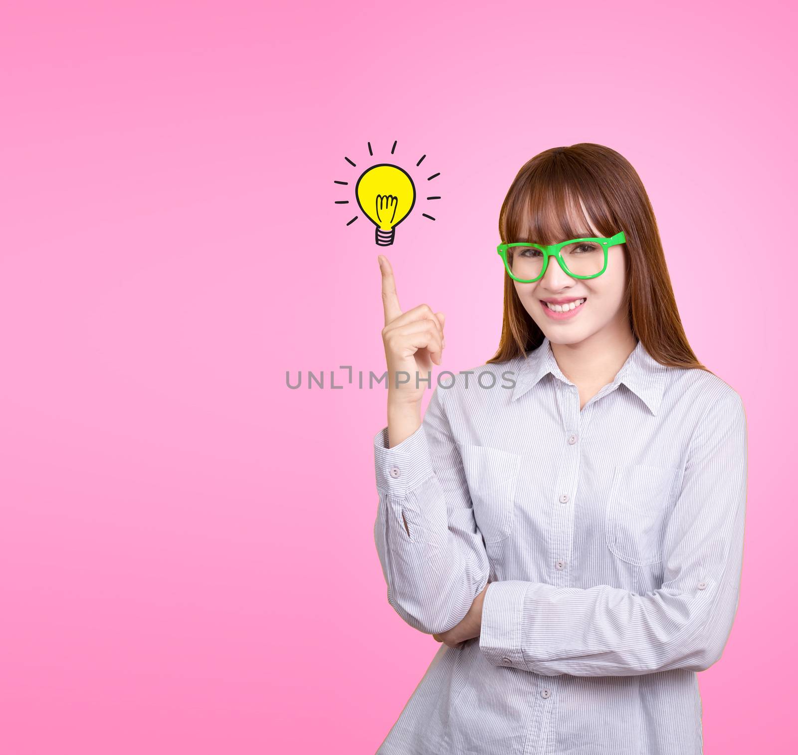 Business Asian woman with green glasses stand and have idea lamp bulb light on women fingertip pink background, for your design for poster and advertising text. Beautiful Asia female model in her 20s.