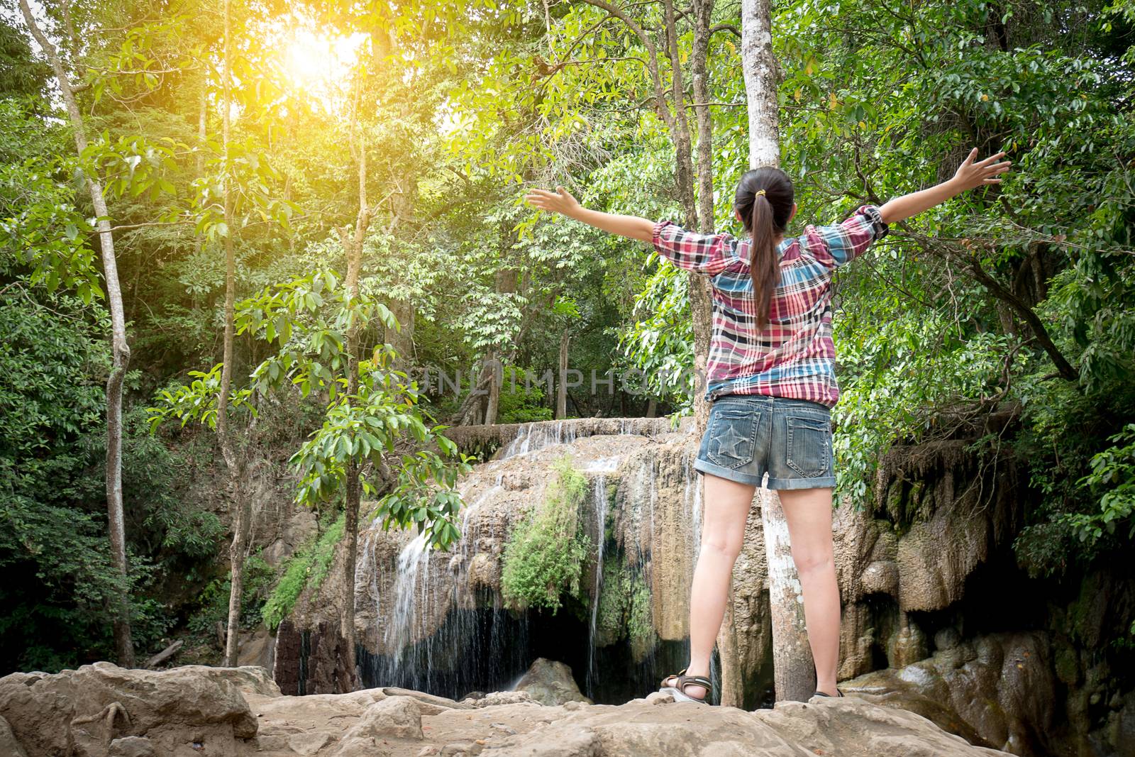 Freedom Asian traveler woman standing with raised arms and enjoying a beautiful nature. by asiandelight