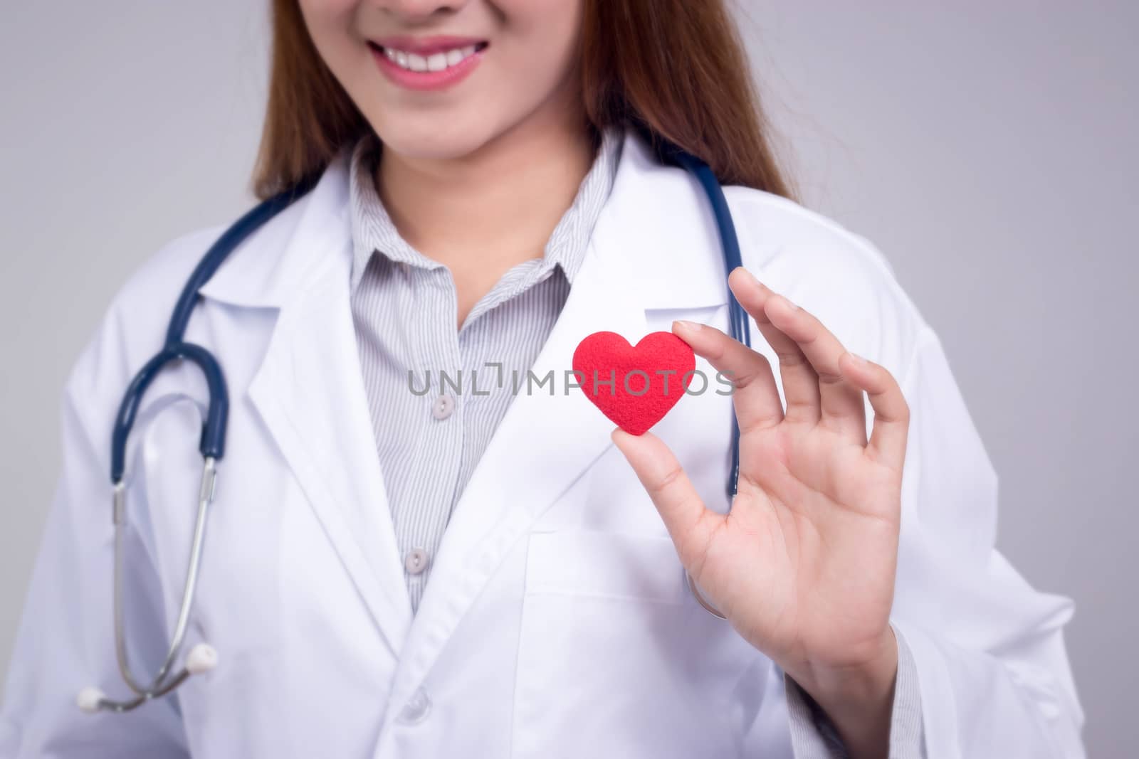 Healthy concept : Young Asian doctor with red heart in hand , anonymous face by asiandelight