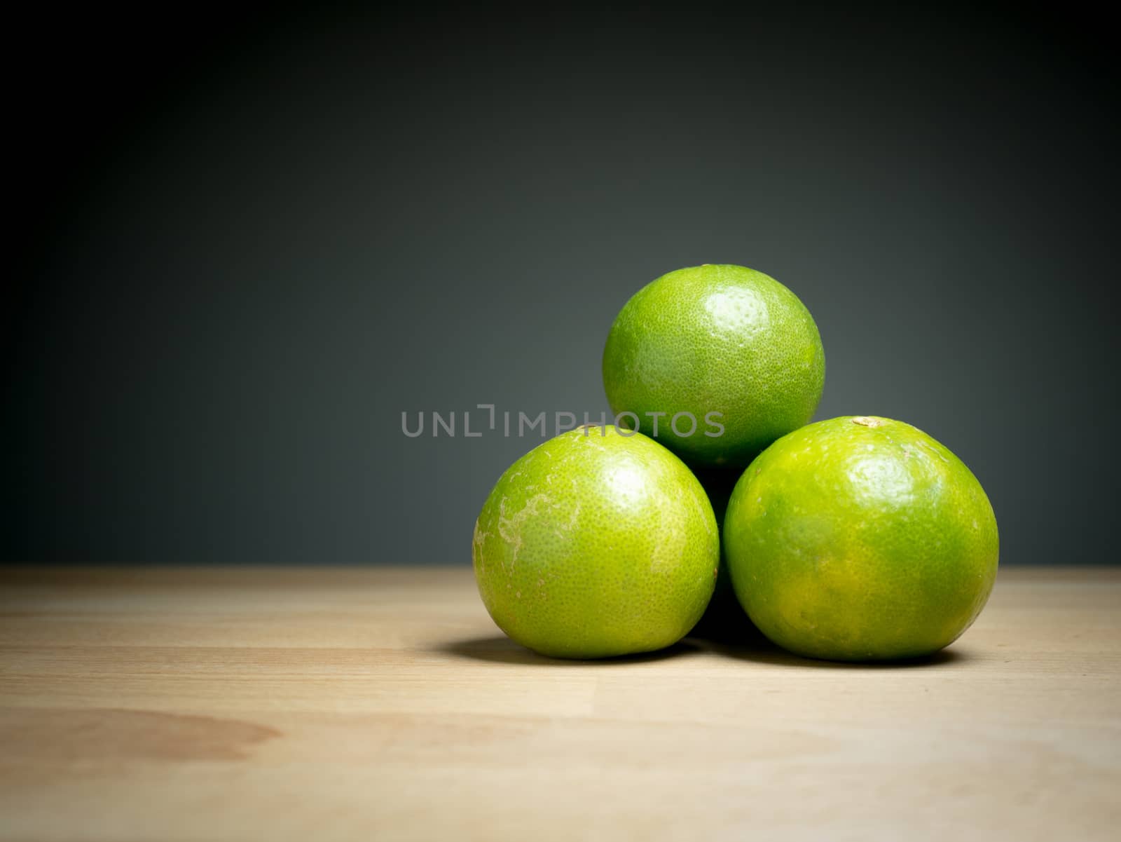Close up green lemons on wooden table