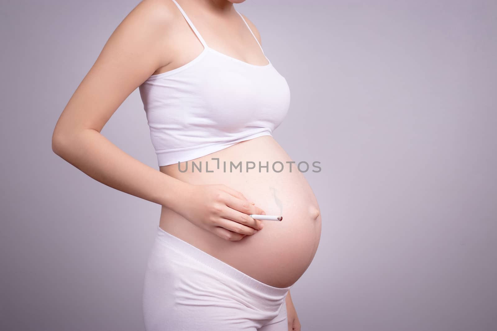 Pregnant healthy concept. Pregnant woman with cigarette in hand. by asiandelight