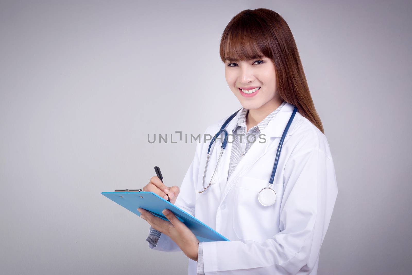 Healthy concept : Young Asian doctor writing on clipboard  for patient chart by asiandelight