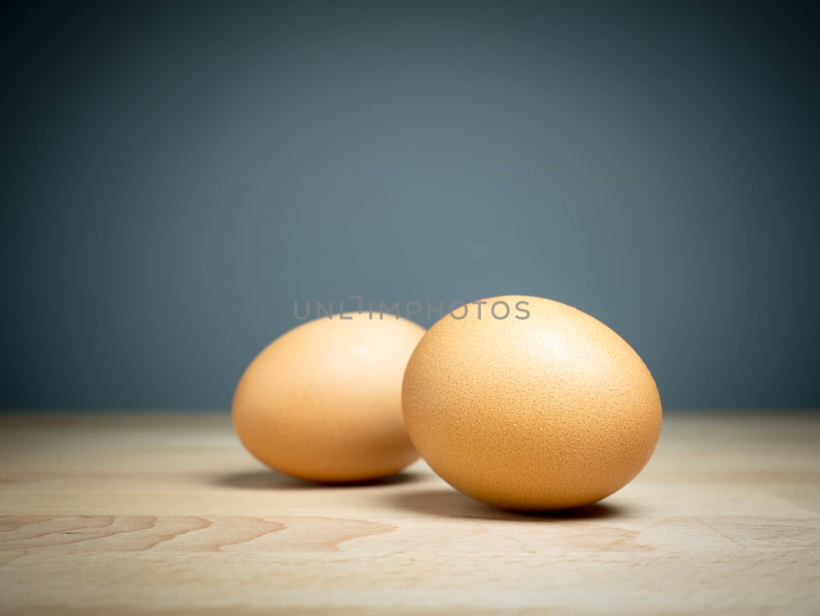 Close up two eggs on wooden table by asiandelight