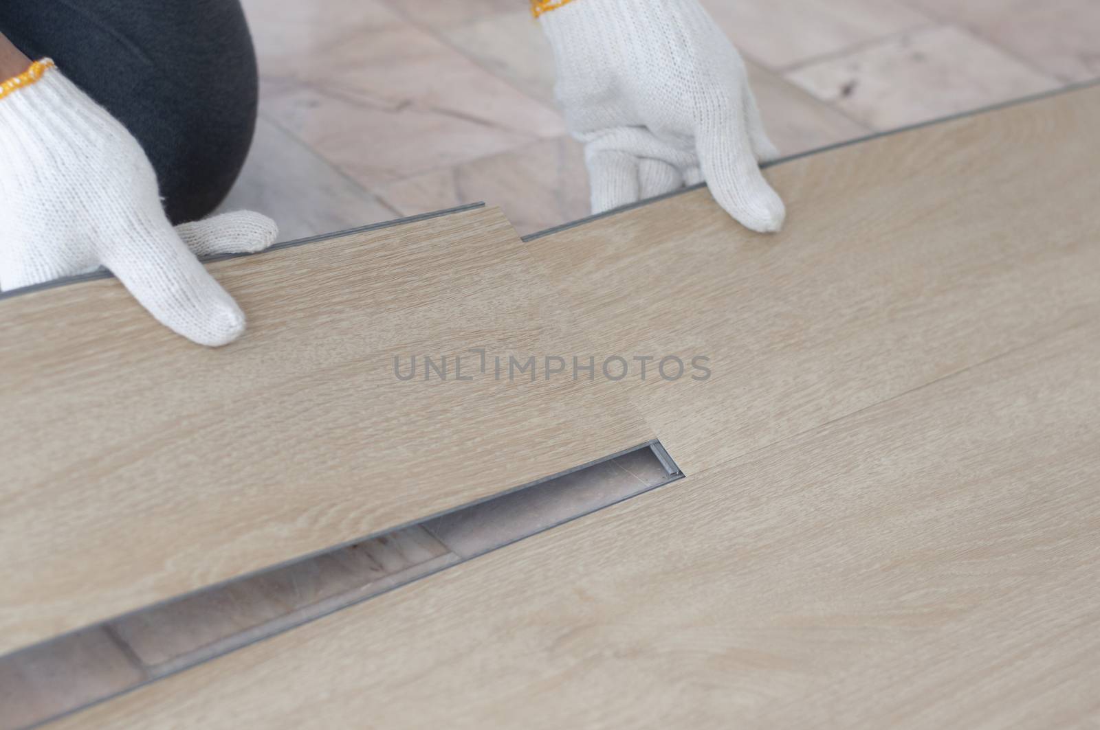 Hand of worker installing wood laminate vinyl floor. Copyspace f by Kingsman911