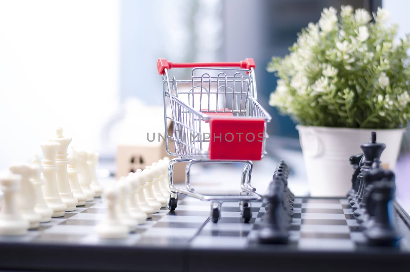 shopping online concept :Shopping Cart onthe box with paper home mock up. Shooping online delivery at home.Work desk blur background.Copyspace for text. nobody.Online Delivery. 