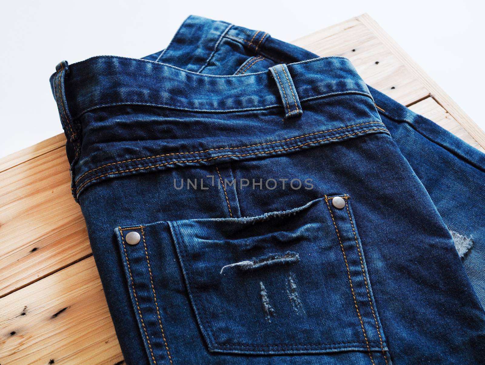 Denim blue jeans trouser fashion placed on wooden boxes