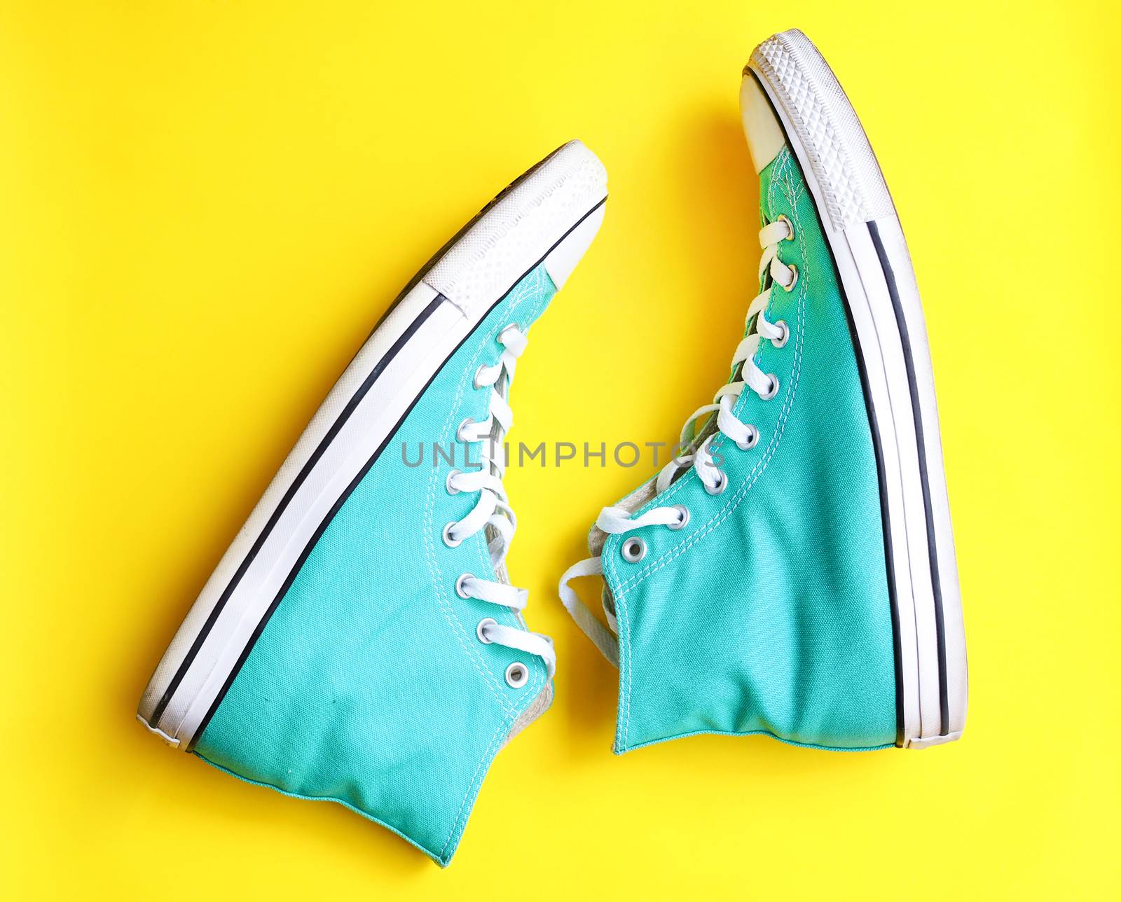 Blue sneakers Teen Fashion shoe isolated on yellow background. by kittima05