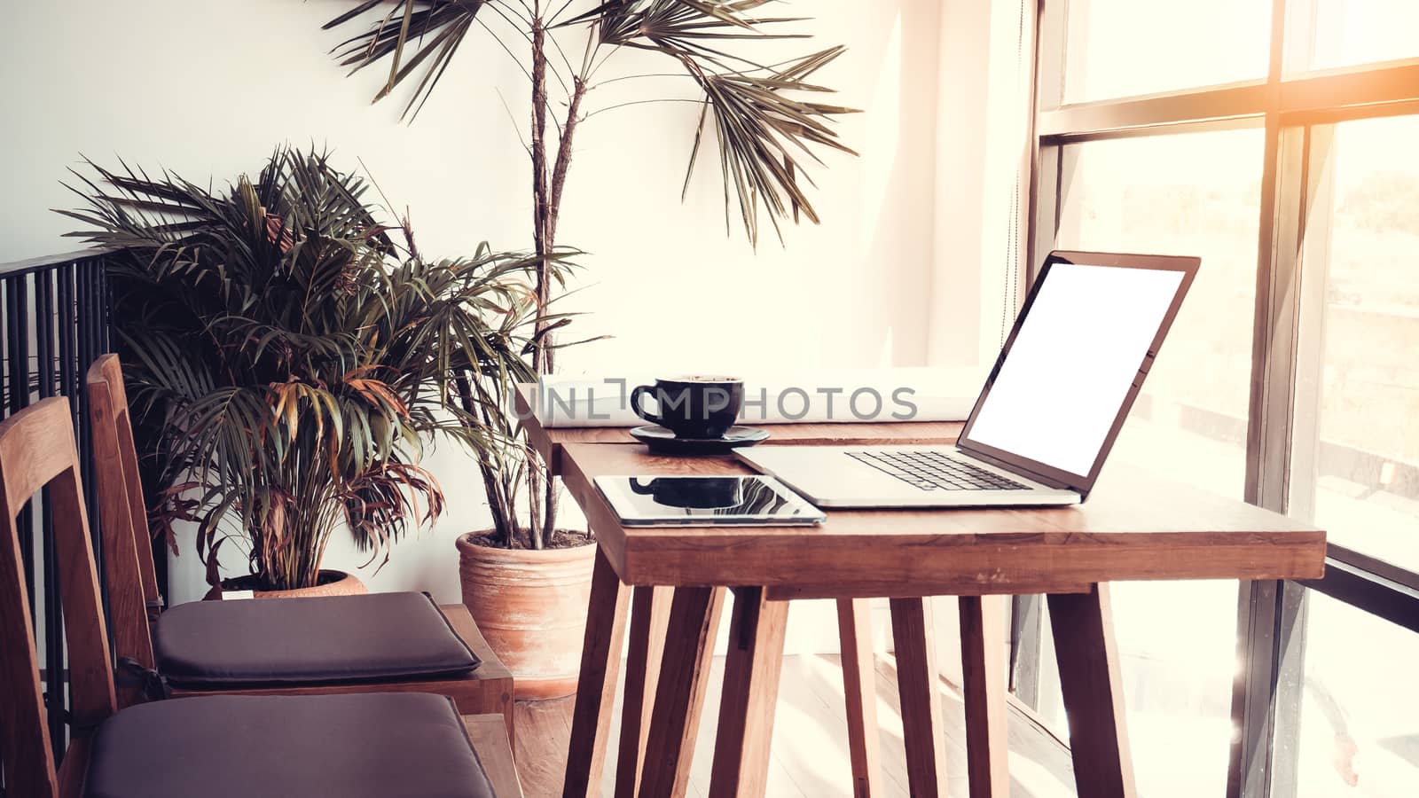 Office workplace with laptop on wood table against the windows. by asiandelight